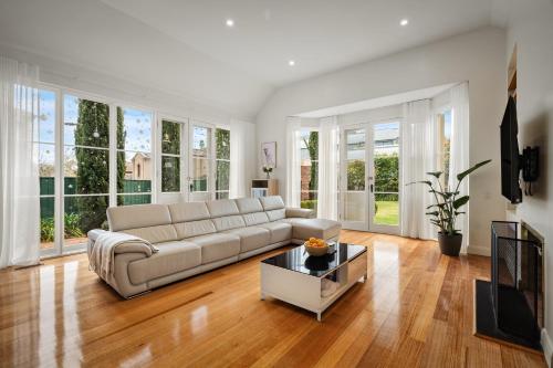 a living room with a couch and a table at Charming Red Brick Estate in Kew 5BR & Playhouse in Melbourne