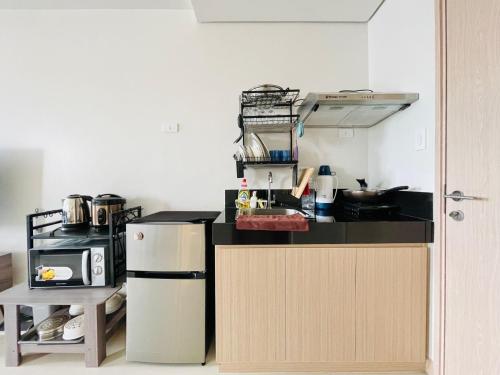 a kitchen with a refrigerator and a microwave at Elegant Style Studio in SMDC in Cari Mayor