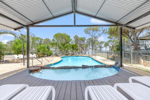 a large swimming pool with white chairs in a pavilion at BIG4 Lake Maraboon Holiday Village in Gindie