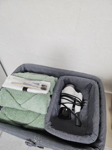 a suitcase with a towel and a toothbrush and a book at 목포 달달마실 게스트하우스 in Mokpo