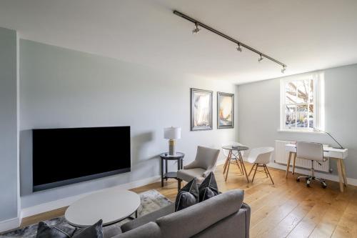a living room with a flat screen tv on a wall at Luxurious Private One Bedroom Apartment with Sky TV, Movies & Netflix in Braintree