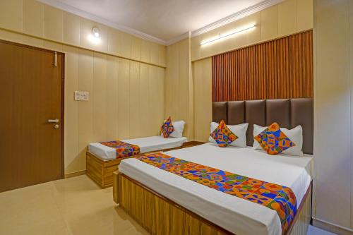 a hotel room with two beds and a door at Collection O Baner Hillview Pune Formerly Siri Lodge in Méribel Village