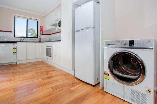 a white kitchen with a washing machine in a room at BIG4 Traralgon Park Lane Holiday Park in Traralgon