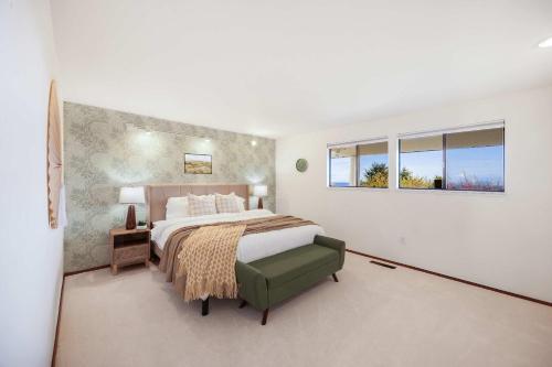 a bedroom with a large bed and two windows at Bellevue Somerset 2BR w Sunroom & Sweeping Views in Newcastle