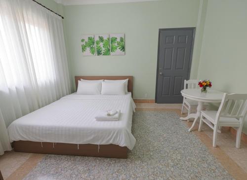 een slaapkamer met een groot bed met een tafel en een deur bij Lux saigon airport in Ho Chi Minh-stad