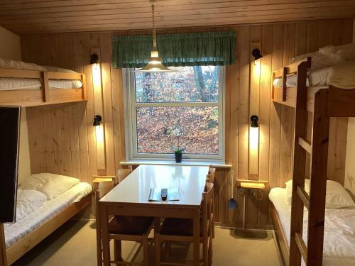 Detached holiday home for four guests في Ansager: غرفة مع سرير بطابقين وطاولة ونافذة