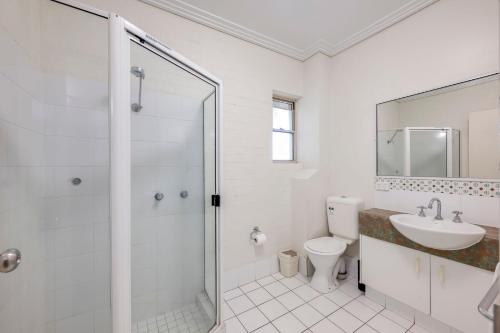 een badkamer met een douche, een toilet en een wastafel bij Shoreline Apartments - Unit 4b in Bargara