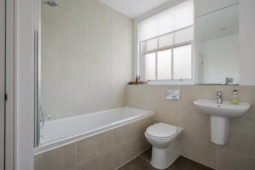 a bathroom with a tub and a toilet and a sink at Luxurious Private One Bedroom Apartment with Sky TV, Movies & Netflix in Braintree