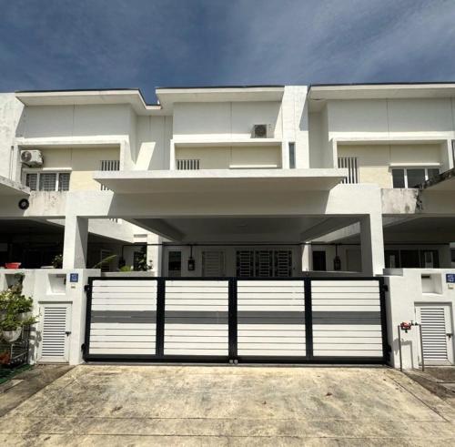 a white house with a white garage door at Suriaman Serenity Comfort Home 4R4B 芙蓉宁静舒适之家 4房4卫 in Kampong Gadong Jaya