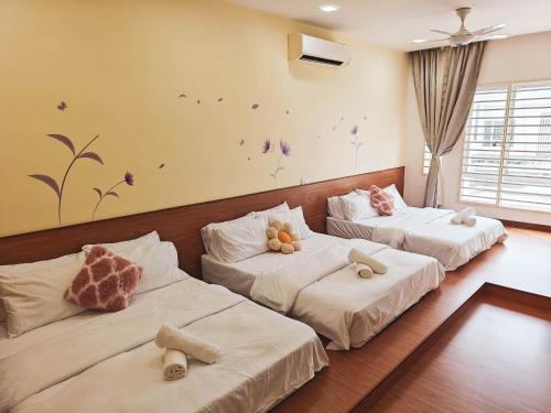 a room with three beds with stuffed animals on them at Suriaman Serenity Comfort Home 4R4B 芙蓉宁静舒适之家 4房4卫 in Kampong Gadong Jaya