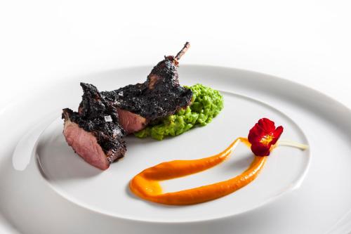 a plate of food with meat and vegetables on it at Trump International New York in New York