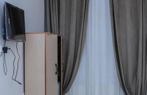 a tv sitting on top of a cabinet next to a curtain at The Egyptian apartment in Cairo