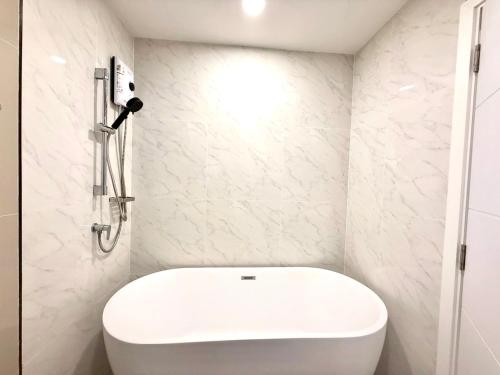 een badkamer met een wit toilet en een douche bij AVALYN Room Plus II - East Ville in Ban Hua Khao Sammuk