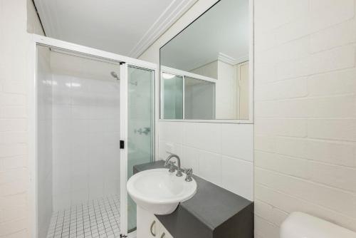 a white bathroom with a sink and a shower at Shoreline Apartments - Unit 4a in Bargara