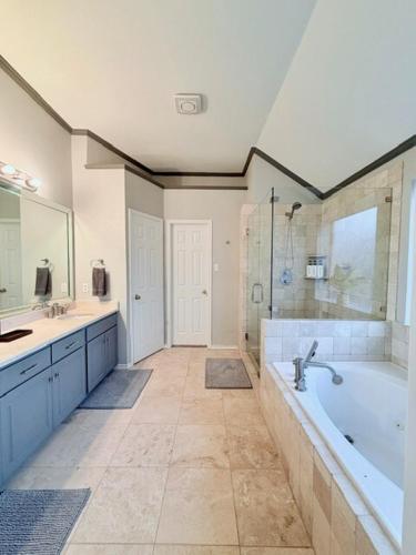 a large bathroom with a tub and a sink at Spacious Centrally Located with Heated Pool in Frisco