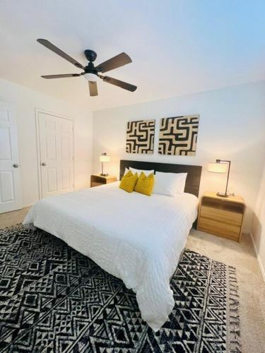 a bedroom with a large white bed with a ceiling fan at Spacious Centrally Located with Heated Pool in Frisco