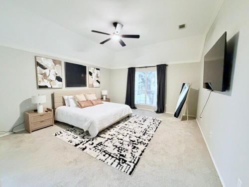 een witte slaapkamer met een bed en een plafondventilator bij Spacious Centrally Located with Heated Pool in Frisco