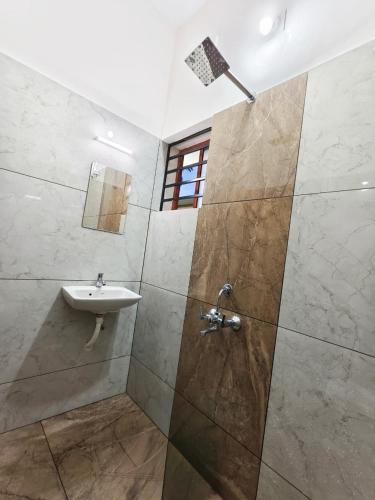 a bathroom with a sink and a shower at Urban villa in Trivandrum