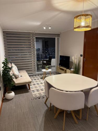 Frente a Playa Brava, Cerca Cavancha, WiFi في إكيكي: غرفة معيشة بها طاولة وأريكة