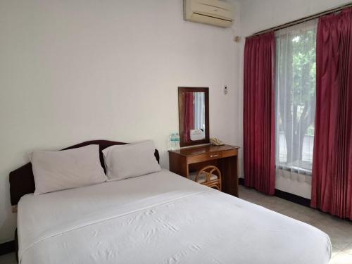 a bedroom with a white bed and a window at Grand Ciwareng Inn Hotel and Resort in Pasarsenen