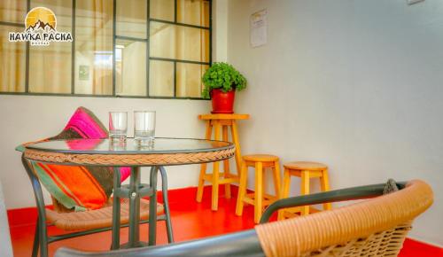 Una mesa y sillas en una habitación con una mesa. en hawka pacha cusqueña, en Cusco