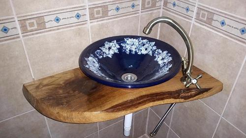 a blue sink with flowers in it in a bathroom at Pensiunea Agroturistica Cerna, Vaideeni - Polovragi in Vaideeni