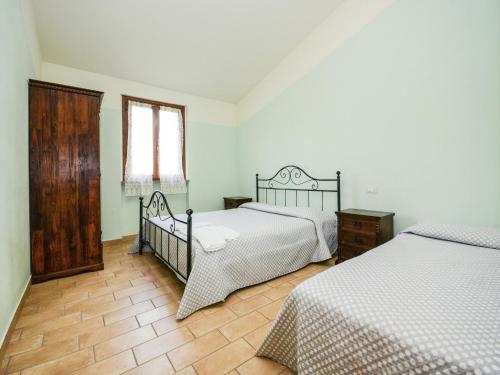 a bedroom with two beds and a window at Mansion in Apecchio with Pool in Apecchio