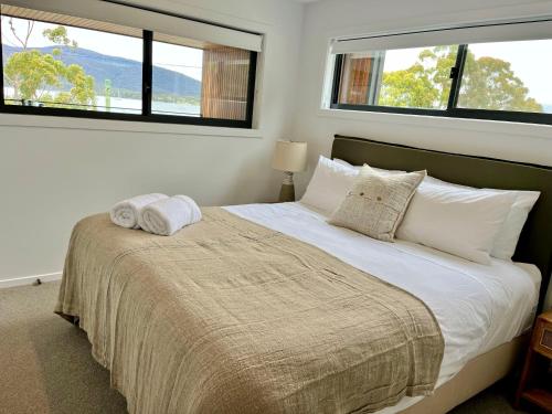 Un pat sau paturi într-o cameră la Bay View Retreats- Ocean mist