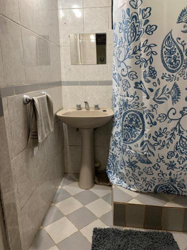 Un baño con lavabo y cortina de ducha. en Cabañas Canaan, en La Cumbre