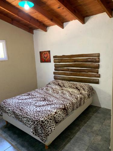 Un dormitorio con una cama con estampado de leopardo en una habitación. en Cabañas Canaan, en La Cumbre