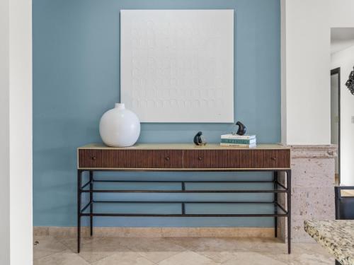 a console table in a living room with a blue wall at Beautiful Apartment a few of minutes to the Beach in Cabo San Lucas