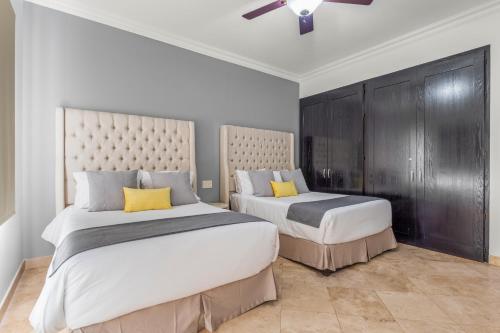 a bedroom with two beds with yellow pillows at Beautiful Apartment a few of minutes to the Beach in Cabo San Lucas