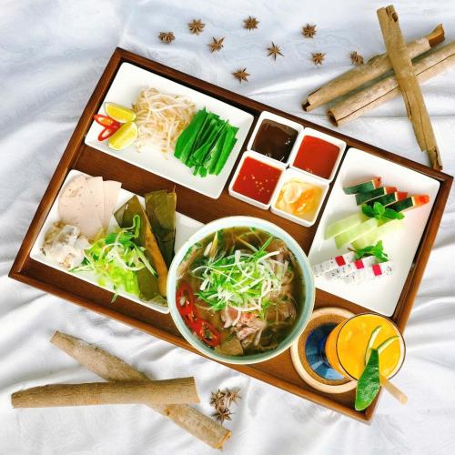 uma bandeja de comida com macarrão e uma tigela de sopa em The Morning Glow - Handwritten Collection em Nha Trang