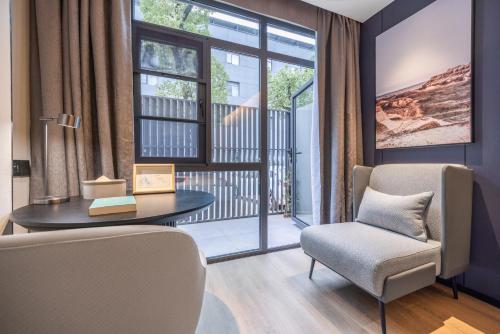 a living room with a table and a chair and a window at Atour Hotel Central China Normal University Wuhan Street Entrance in Wuhan