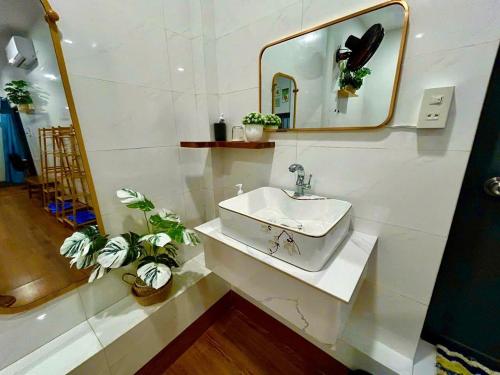 a white bathroom with a sink and a mirror at Dốc Biển Homestay Mui Ne in Ấp Khánh Phước (1)