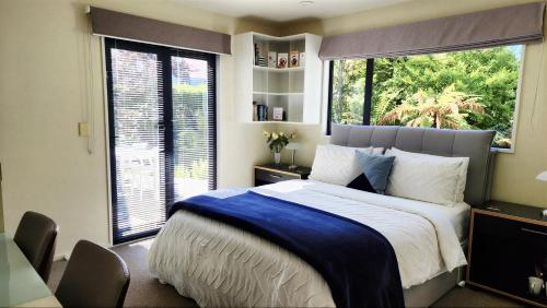 a bedroom with a large bed and a large window at Christchurch Airport House in Christchurch
