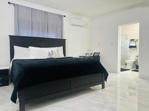 a bedroom with a black bed and a bathroom at Redhills Escape in Kingston