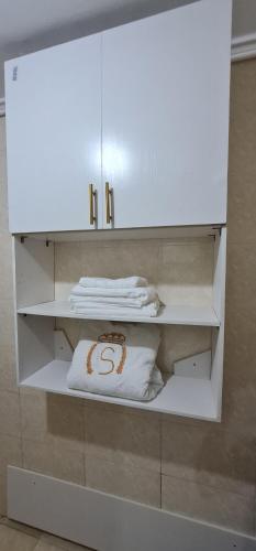ein weißer Schrank mit einem weißen Kissen und Handtüchern in der Unterkunft O'sena in Cotonou