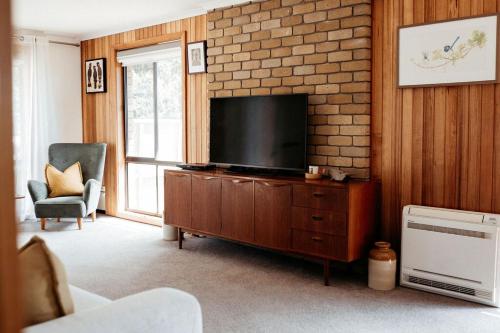 una sala de estar con TV de pantalla plana en un armario de madera en StudioNESS, en Scamander