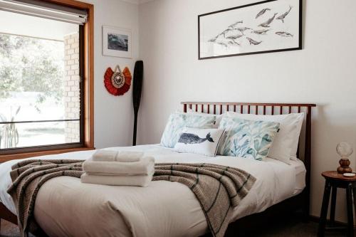 a bedroom with a bed with pillows and a window at StudioNESS in Scamander