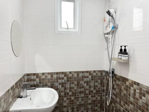 ein Badezimmer mit Waschbecken und Dusche in der Unterkunft Jira Simply room Suvarnabhumi Airport 15 mins in Phrawet