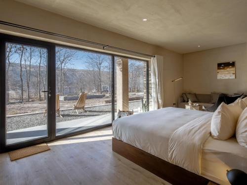 中卫大乐之野（中卫黄河宿集店）的一间卧室，配有一张大床和一扇大窗户。