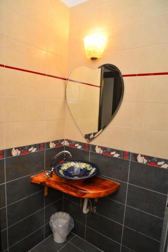 a bathroom with a sink and a mirror at Pensiunea Agroturistica Cerna, Vaideeni - Polovragi in Vaideeni