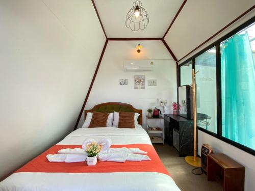 a bedroom with a bed with towels on it at ภูชี้ฟ้าอินน์ รีสอร์ท Phucheefainn Resort in Ban Seng Choi