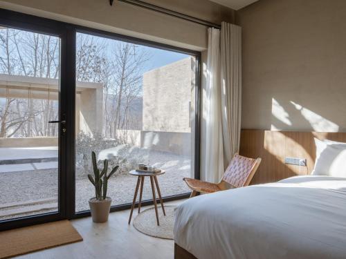 a bedroom with a bed and a large window at LOSTVILLA(Zhongwei Yellow River Dormitory) in Zhongwei