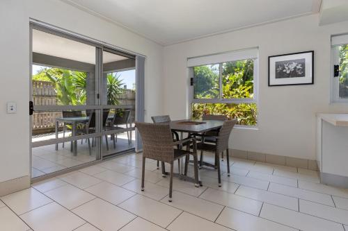 a dining room with a table and chairs and windows at Beachside 7 in Diamond Beach