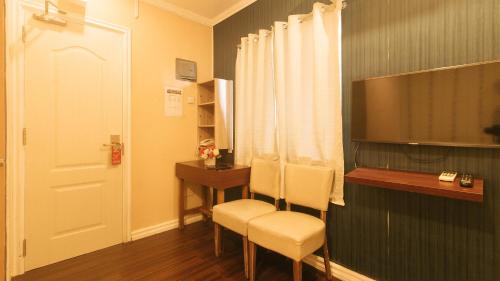 a room with two chairs and a desk and a door at RedDoorz at Emperor Manila Boutique Hotel in Manila
