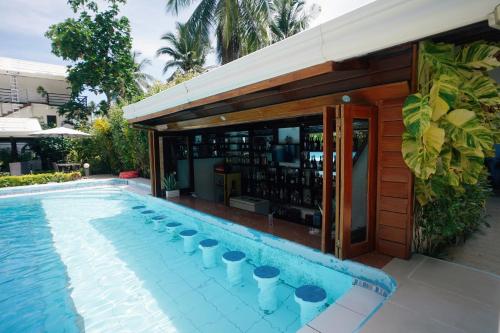 einen Pool mit einer Bar neben einem Gebäude in der Unterkunft Point 303 Resort in General Luna