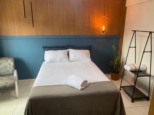 a bedroom with a large bed with a blue wall at Studio 731F Conforto no Coração de Foz do Iguaçu in Foz do Iguaçu