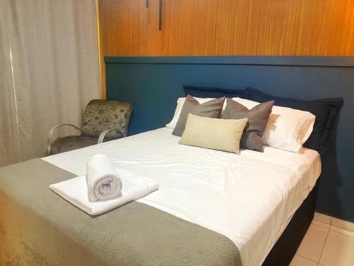 a bed with a hat and towels on it at Studio 731F Conforto no Coração de Foz do Iguaçu in Foz do Iguaçu